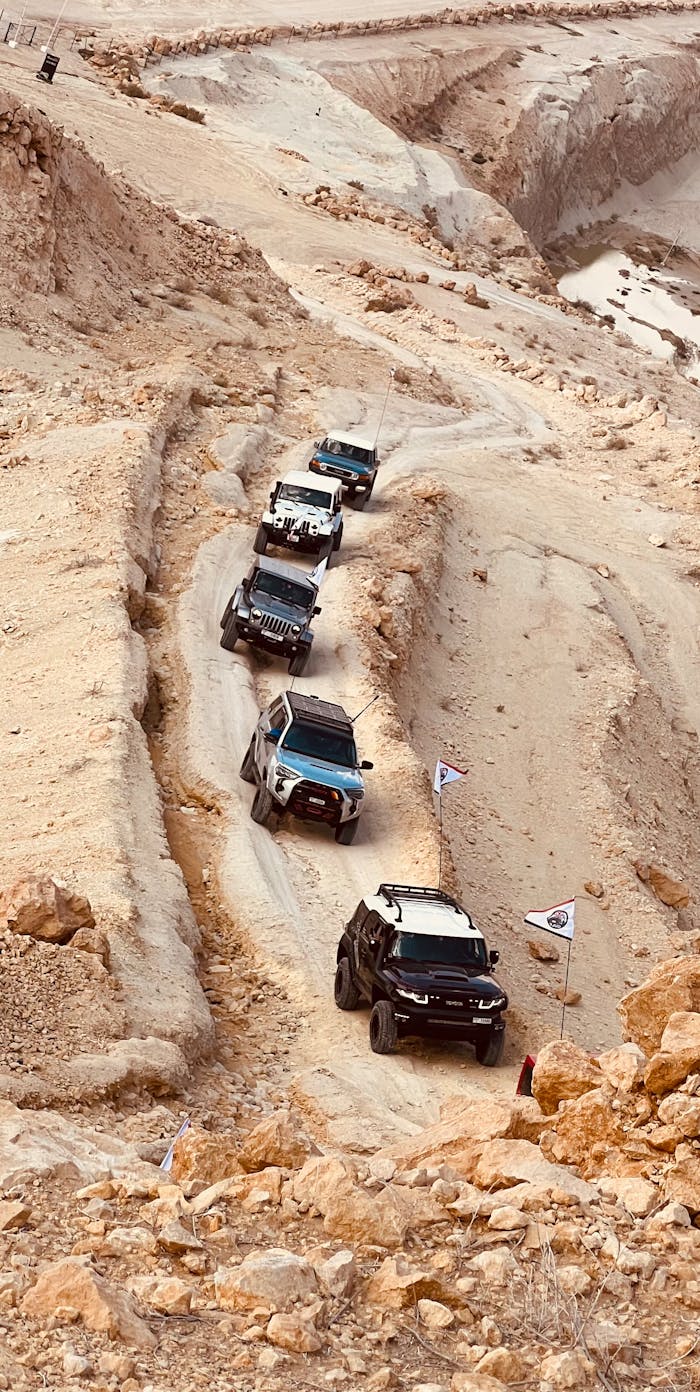 Explore thrilling off-road adventures in Sharjah's rugged desert terrain with a convoy of 4x4 vehicles.